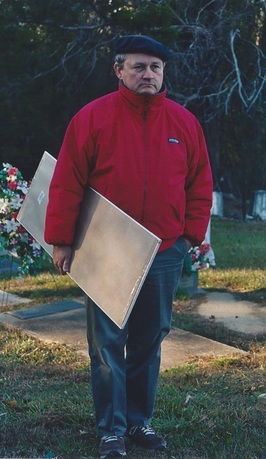  Ian W. Brown uses a mirror to reflect sunlight, making it easier to read gravestone inscriptions. Photo taken at New Asia Cemetery, Tuscaloosa in 2005 (courtesy Anna Mullican 6-9-15).